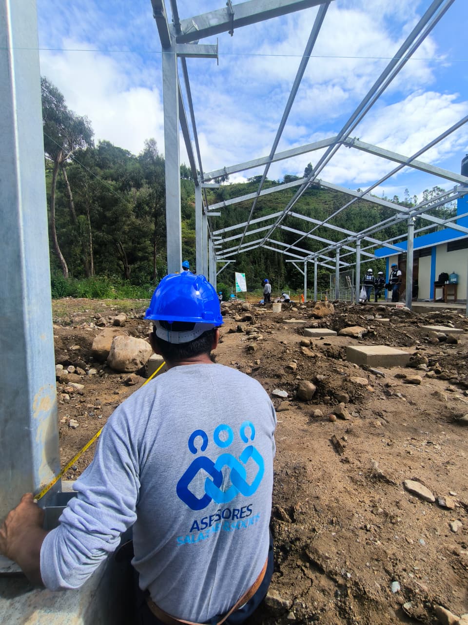 Operario midiendo columna metálica durante el montaje de la estructura del comedor modular.